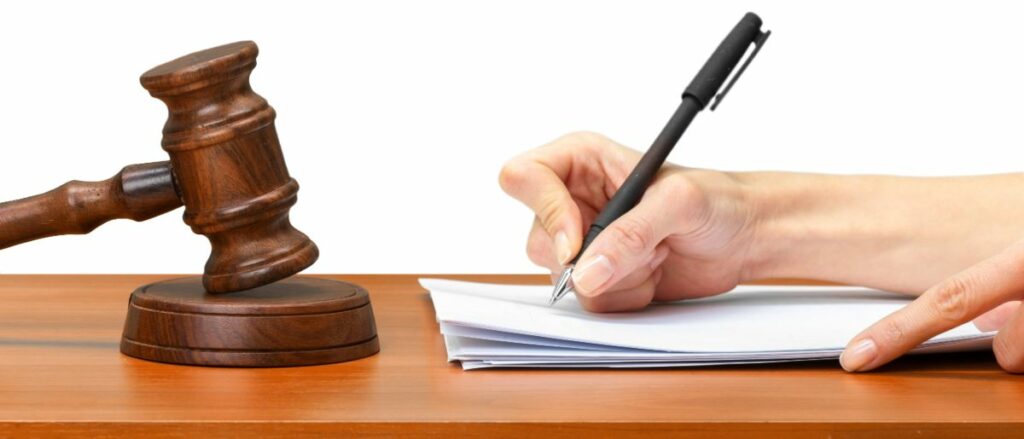 Gavel next to person writing